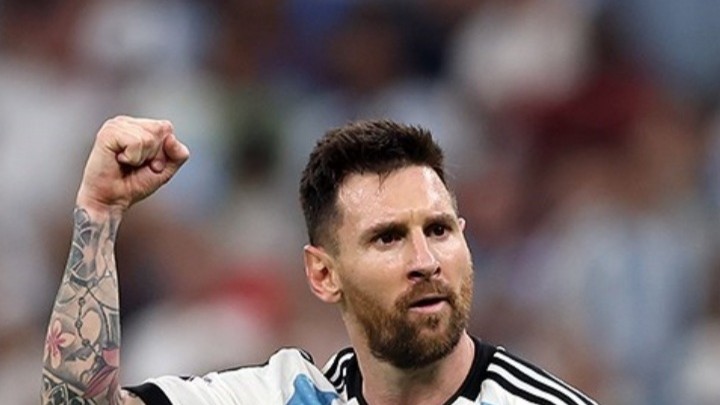Lionel Messi celebrating with a raised fist in Argentina's shirt at the 2022 World Cup.