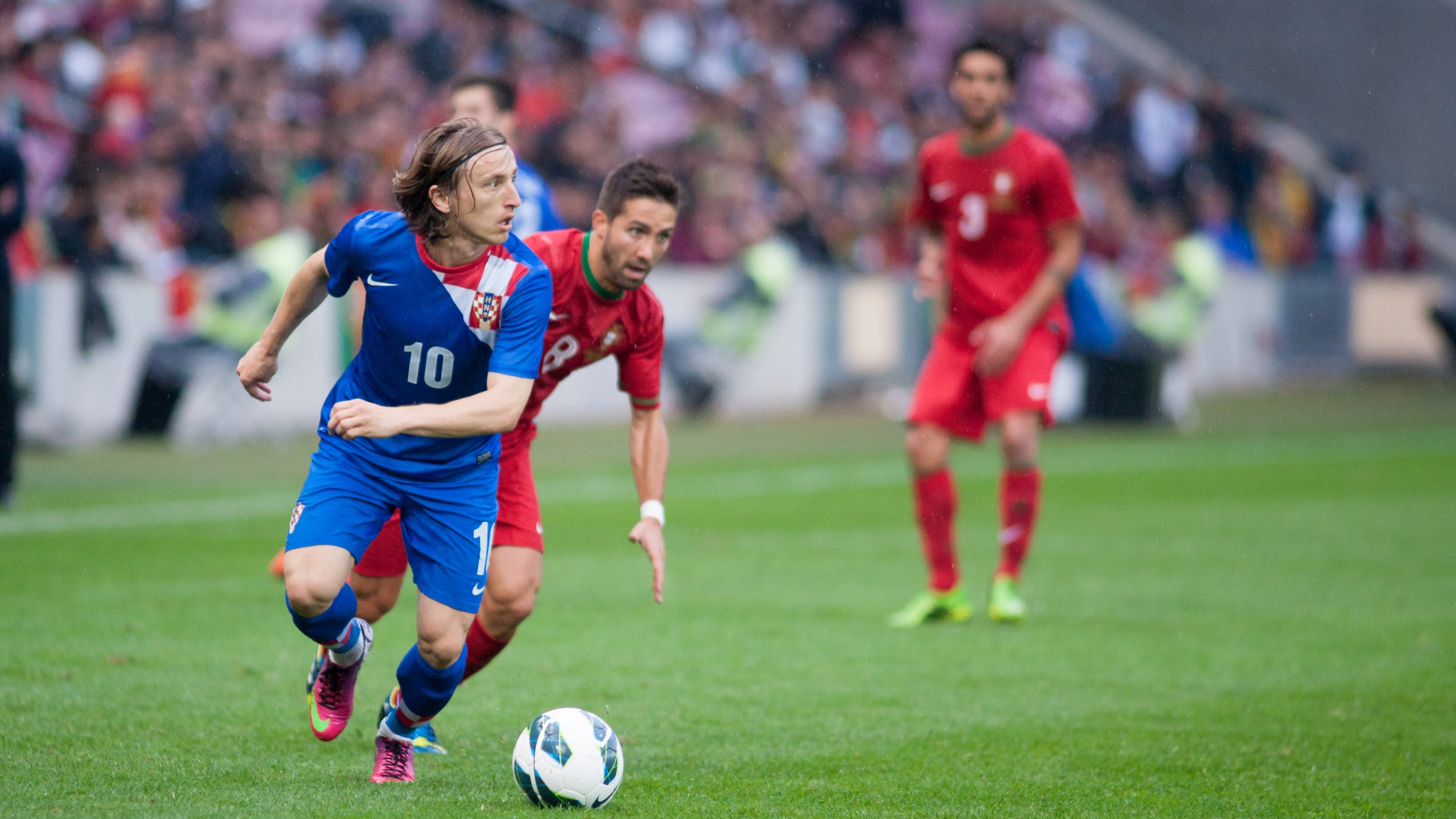 Luka Modrić driving forward with the ball in Croatia's blue shirt, number 10.